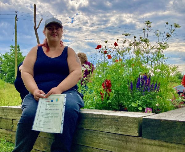 woman sitting next to garden